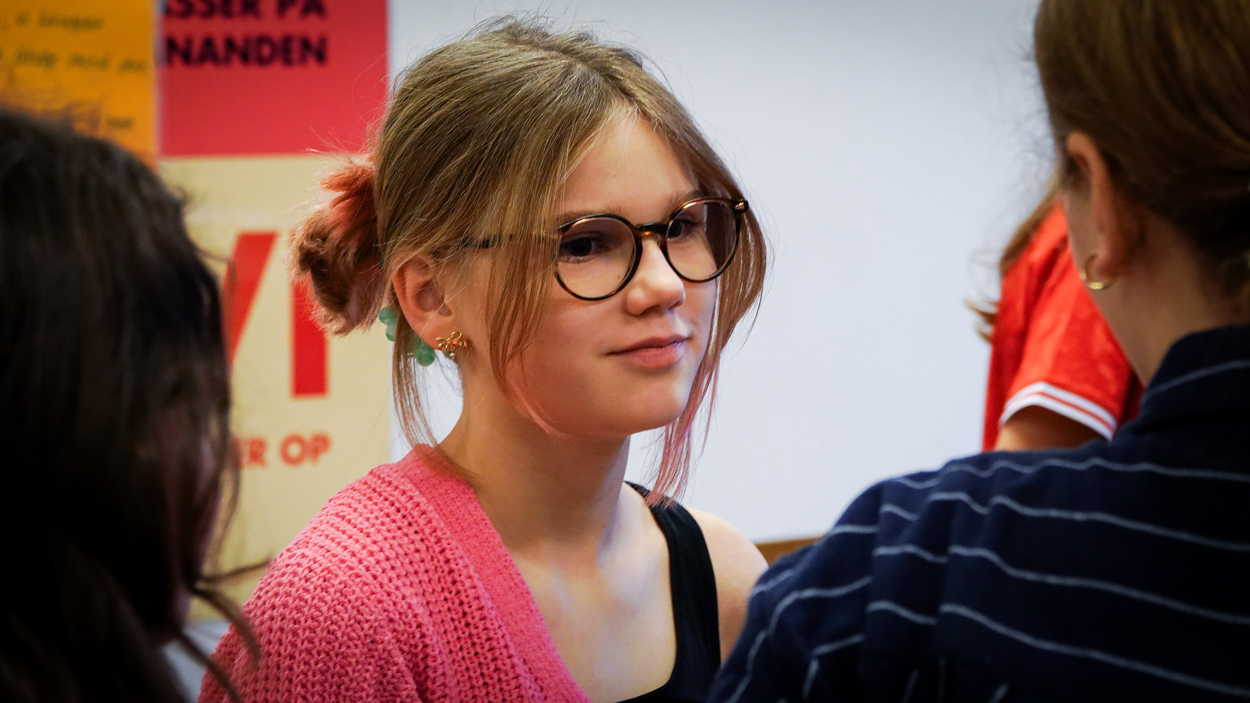 Pige i klasselokale kigger på skolekammerat